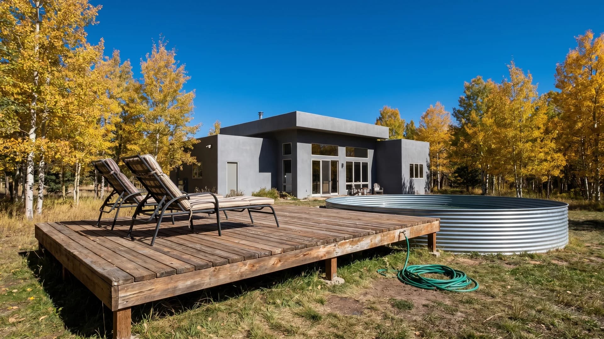 Ground level floating deck next to an above ground pool at a modern gray house in Colorado