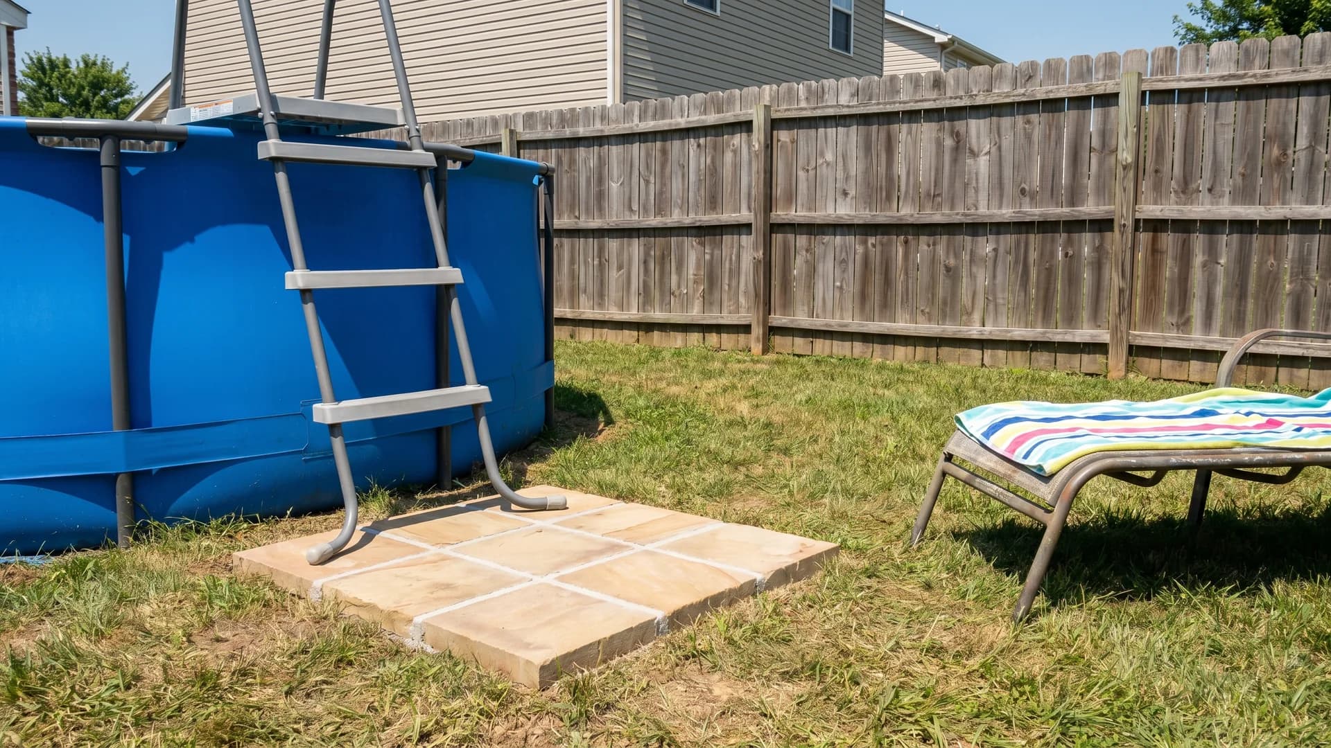 Square paver pad at the base of an above ground pool ladder with sandstone pavers