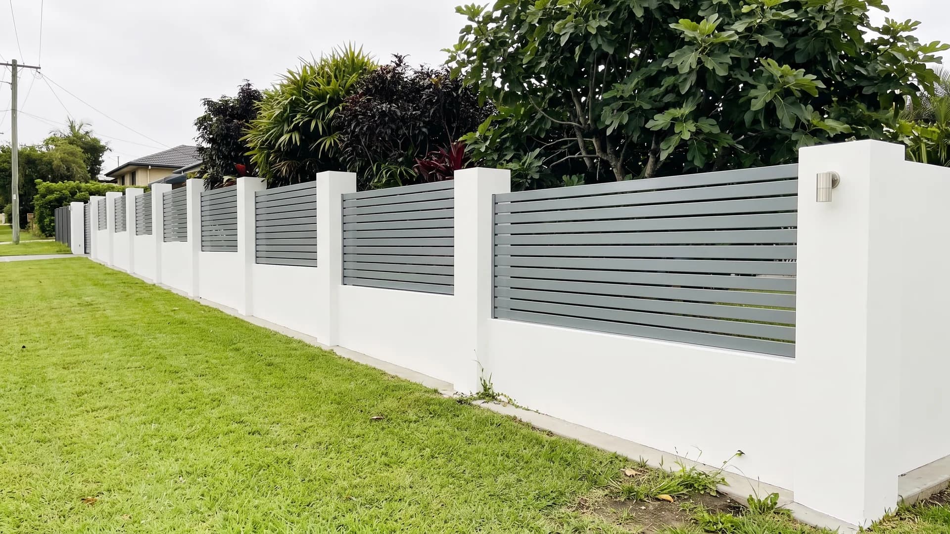 Grey aluminium horizontal slat panels set into a white rendered wall with pillars
