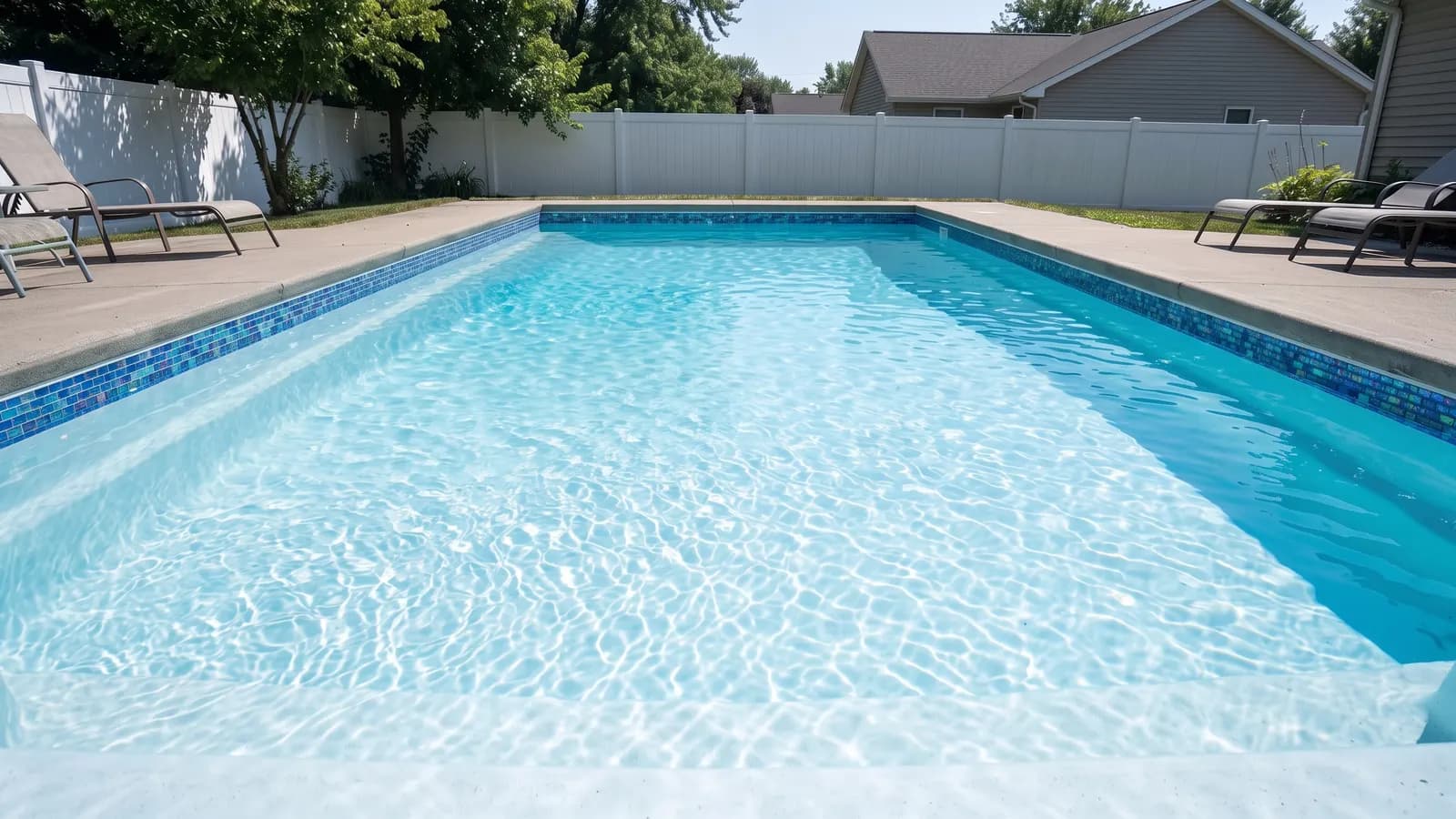 The same pool with an iridescent blue and turquoise glass mosaic tile band running around the waterline