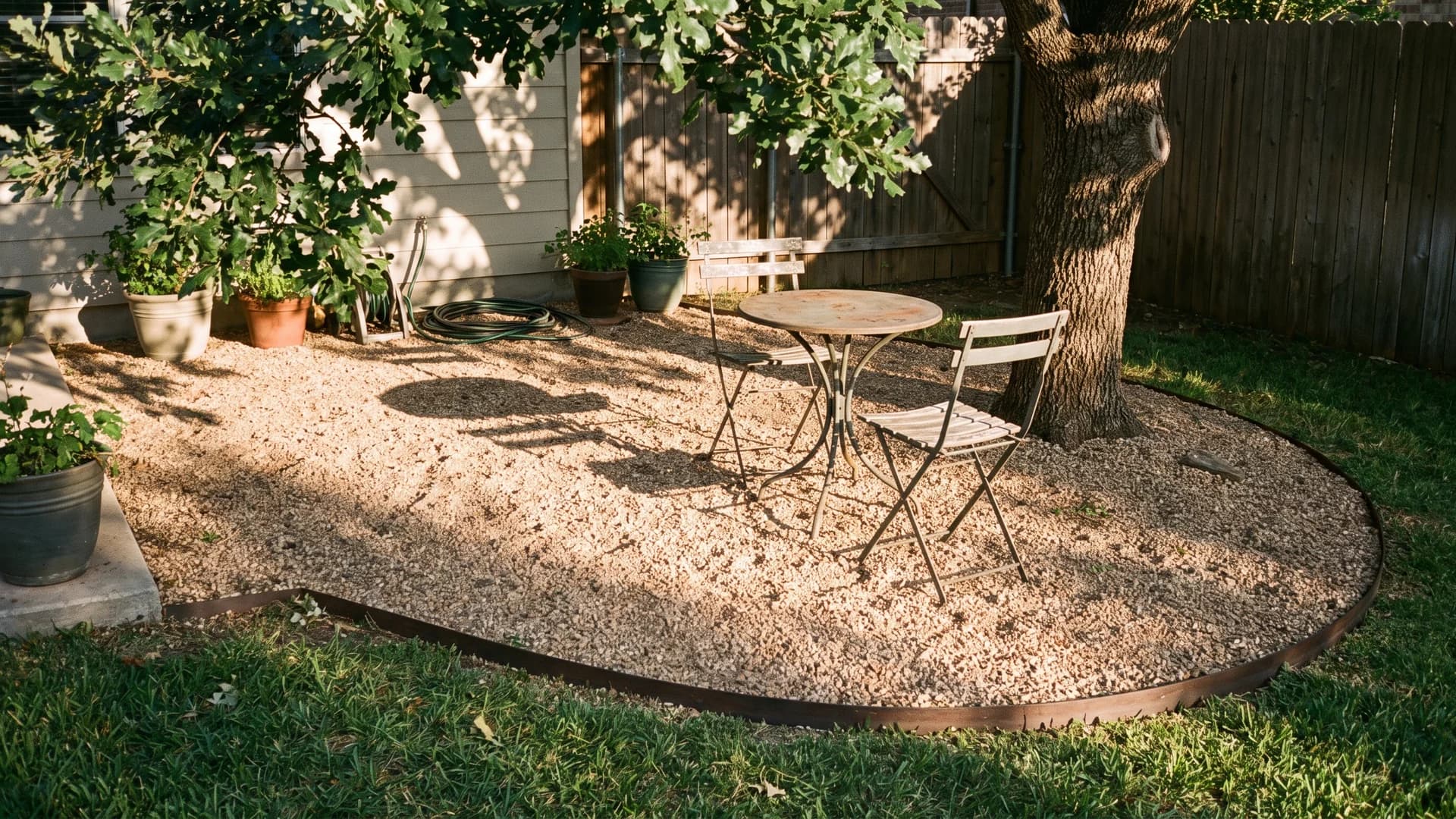 Pea gravel patio with bistro furniture in a small backyard corner