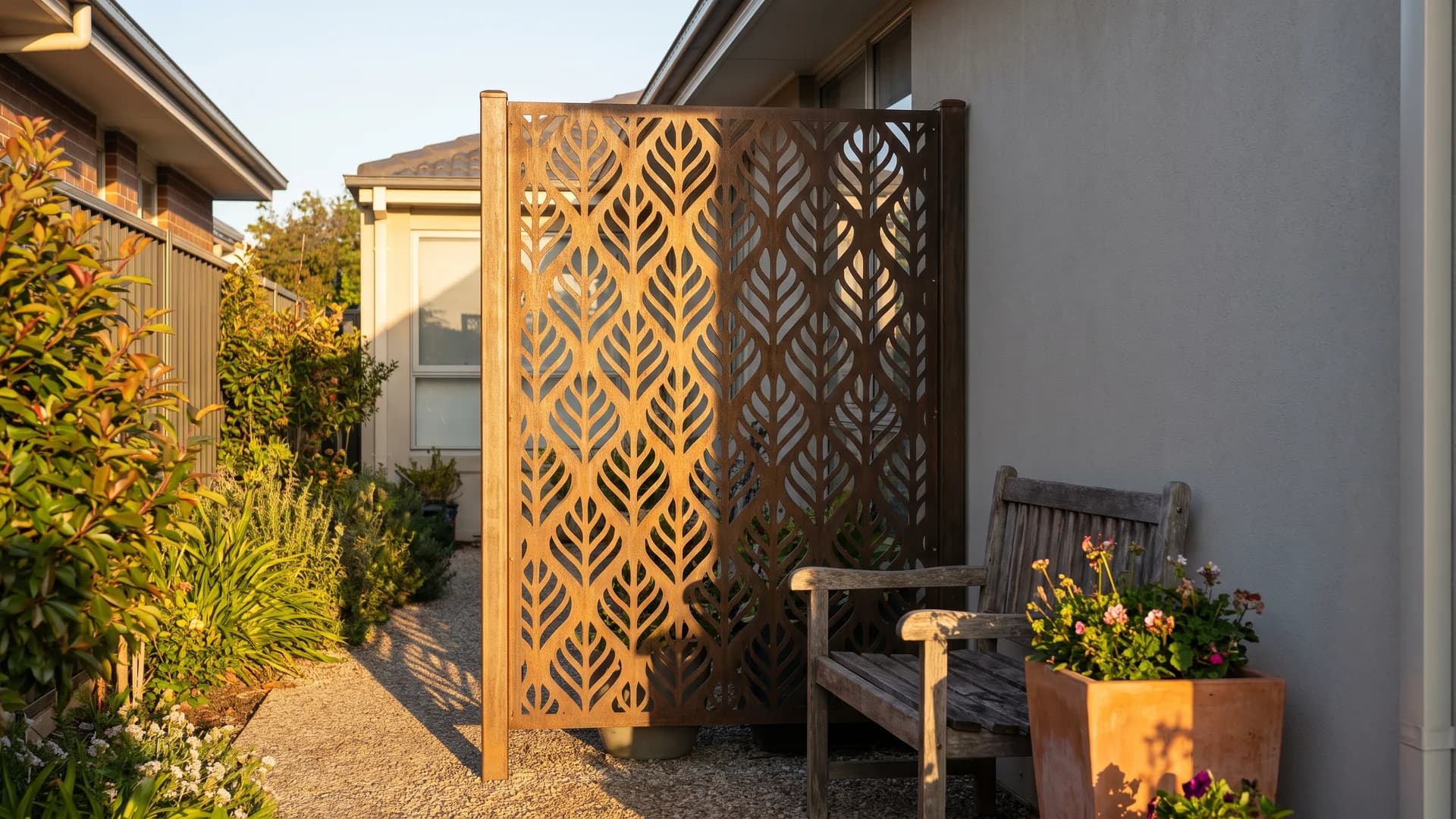 Decorative metal privacy screen panel creating a private corner in a side yard